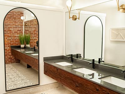 Modern bathroom renovation with dual sinks, black fixtures, and brick accent wall by Dave’s Home Service & Repairs – expert home repairs Belleville.